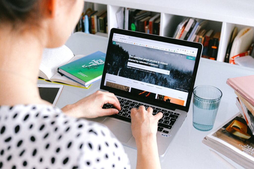 uma mulher sentada fazendo marcacoes online pelo computador do ebooking e airbnb