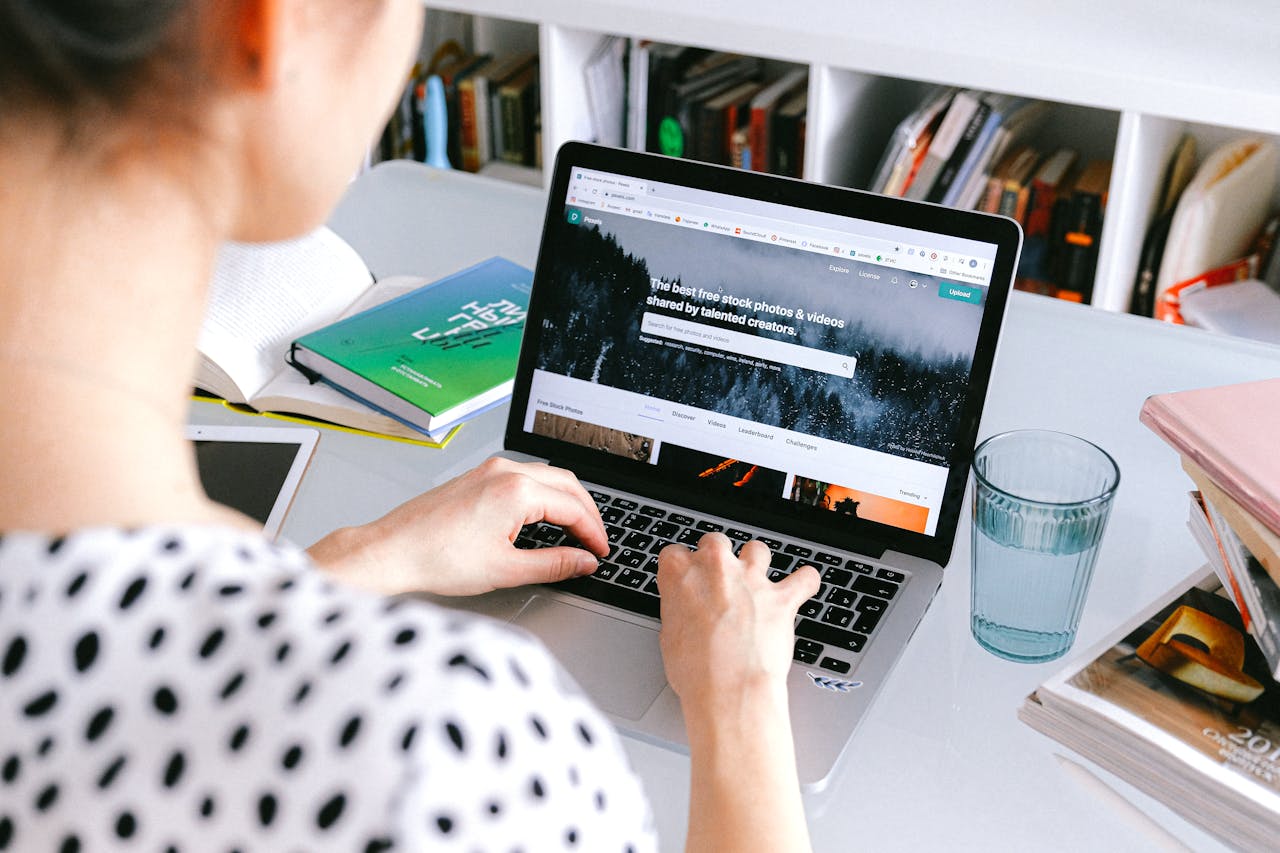 uma mulher sentada fazendo marcacoes online pelo computador do ebooking e airbnb
